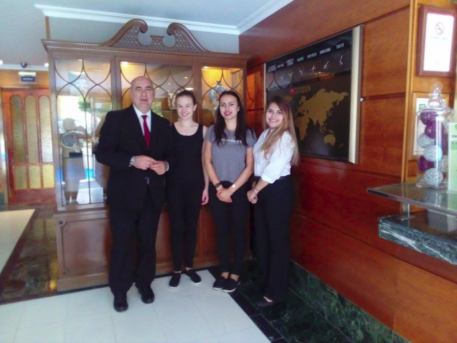 Grupa hotelarek ze swoim tutorem i właścicielem hotelu